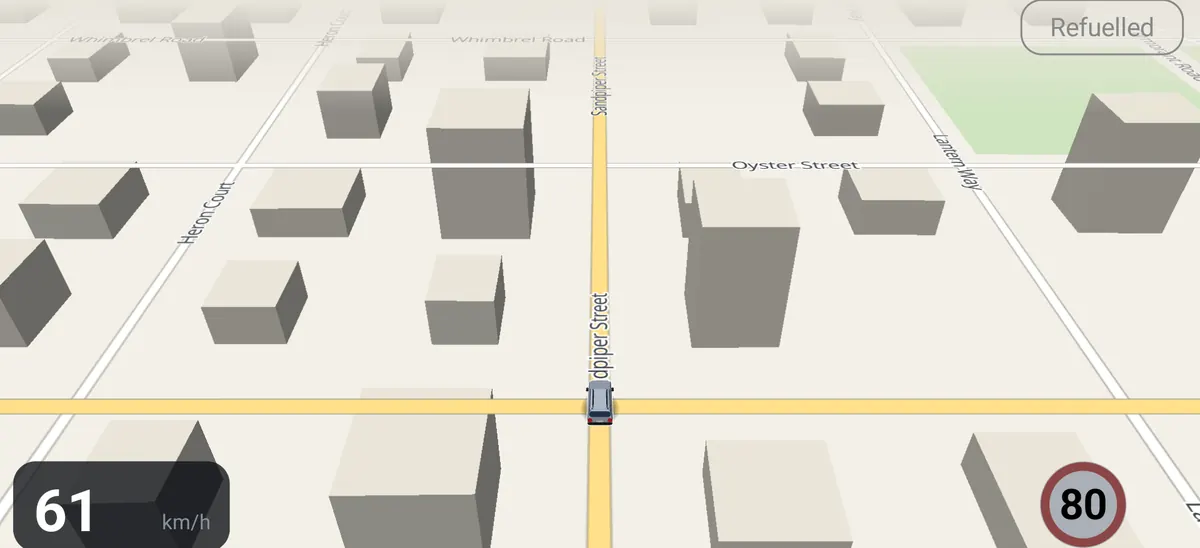 The map view over a made-up town, tilted, with the car, speed and limit sign